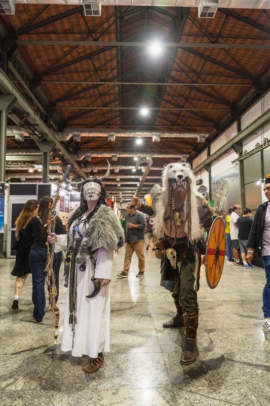 Personagens vikings circulando pelo galpão do festival